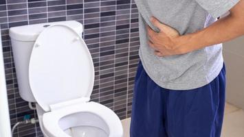 gli uomini hanno contrazioni e mal di stomaco. concetto di diarrea foto