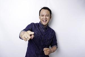giovane asiatico uomo indossare blu camicia in piedi al di sopra di isolato bianca sfondo puntamento dita per telecamera con contento viso. bene energia e vibrazioni. foto