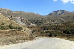 daghestan.russia.settembre 13, 2022. pittoresco montagna paesaggio su il backgroun di il piccolo villaggio.il creste di montagne partire nel righe per il orizzonte. foto