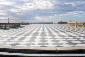 livorno,italia-novembre 27, 2022 persone passeggiando su il mascagni terrazza, un' splendida belvedere terrazza con scacchiera pavimentata superficie, Livorno, Toscana, Italia durante un' soleggiato giorno. foto