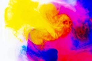 foto di arcobaleno flussi di dipingere nel acqua. dinamico disegno di inchiostro fluire. riccioli e turbinii di liquidi. astratto luminosa modello.