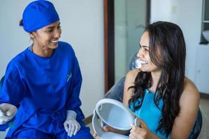 femmina dentista parlando per sua paziente a dal dentista ufficio. foto