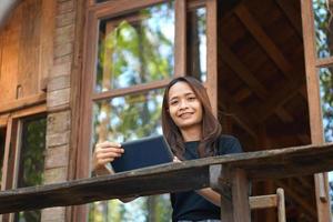 asiatico donne siamo contento per sedersi e opera nel un' caffè negozio. Là siamo verde alberi circondato di natura. attività commerciale pianificazione è un' bene idea. foto