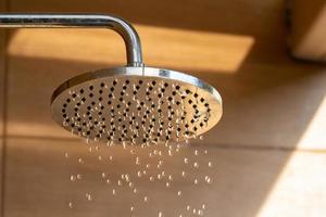 vicino su per all'aperto doccia testa per il bagno e fare la doccia freddo acqua per corpo prima salto nel il ricorrere piscina. foto