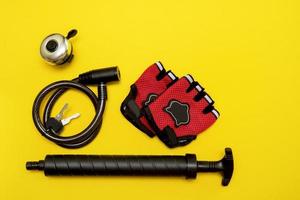 bicicletta Accessori - guanti, pompa, campana, serratura su un' giallo sfondo foto