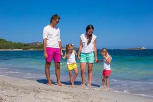 famiglia di quattro su spiaggia vacanza nel Italia foto