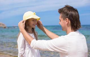 contento padre e adorabile poco figlia avere divertimento a bianca sabbioso spiaggia foto