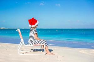 poco adorabile ragazza indossare Santa cappello a caraibico spiaggia foto