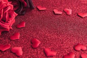 st. concetto di san valentino. rose rosse scarlatte e molti cuori rossi su sfondo rosso glitter. banner da cartolina il giorno di San Valentino. data d'amore simbolo di romanticismo di matrimonio malato d'amore. regalo di San Valentino. foto