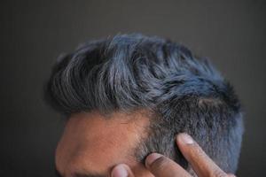 concetto di perdita di capelli con l'uomo che controlla i suoi capelli foto