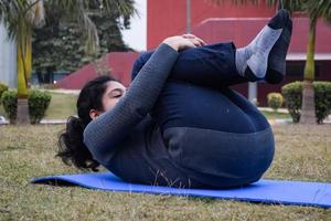 giovane indiano donna praticante yoga all'aperto nel un' parco. bellissimo ragazza pratica di base yoga posa. quiete e relax, femmina felicità. di base yoga pose all'aperto foto