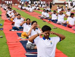 nuovo delhi, India, giugno 21 2022 - gruppo yoga esercizio sessione per persone a yamuna gli sport complesso nel delhi su internazionale yoga giorno, grande gruppo di adulti frequentando yoga classe nel cricket stadio foto