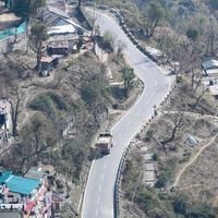 vista aerea dall'alto dei veicoli stradali che guidano su strade di montagna a nainital, india, uttarakhand, vista dal lato superiore della montagna per il movimento di veicoli stradali foto