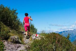 ragazza passeggiate nel il montagne con bastoni. foto