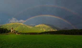 vero pieno Doppio arcobaleno nel un' montagna prato foto