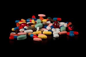 medicinali nel capsule di molti colori su un' nero sfondo foto