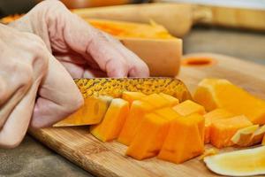 capocuoco tagli zucca nel il forma di Pera su di legno tavola nel il casa cucina foto