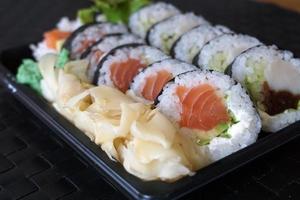 affettato rotoli di salmone e crudo tonno Sushi nel plastica contenitore foto