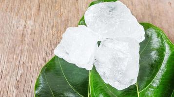 cristallo chiaro allume cubi o potassio allume su verde le foglie chimico composto sostanza concetto per bellezza terme e ascelle trattamento industriale foto