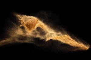 esplosione di sabbia di fiume secca. spruzzi di sabbia di colore marrone su sfondo nero. foto