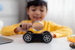 gli studenti asiatici imparano a casa a codificare auto robot e cavi di schede elettroniche in stelo, vapore, matematica ingegneria scienza tecnologia codice informatico in robotica per bambini concetto. foto