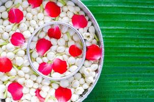 Songkran Festival sfondo con gelsomino fiori nel acqua ciotole per benedizione su bagnato Banana foglia sfondo. foto