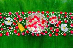 Songkran Festival sfondo con fiori nel acqua ciotole e profumato acqua per benedizione su bagnato Banana foglia sfondo. foto