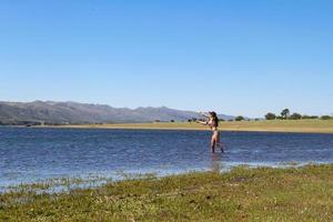 bellissimo giovane donna pesca il montagna lago foto