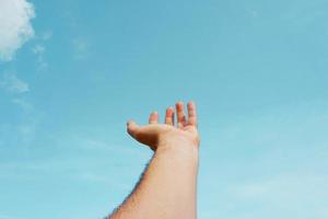 mano su Esprimere a gesti nel il blu cielo, sentimenti e emozioni foto