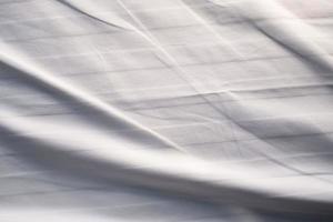 bianca letto biancheria pendenza struttura sfocato curva stile di astratto lusso tessuto, rugoso letto biancheria e buio grigio ombre, sfondo foto