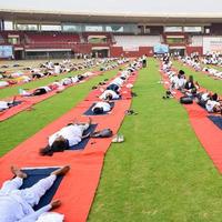 nuovo delhi, India, giugno 21 2022 - gruppo yoga esercizio sessione per persone a yamuna gli sport complesso nel delhi su internazionale yoga giorno, grande gruppo di adulti frequentando yoga classe nel cricket stadio foto