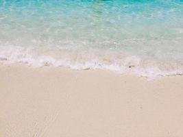 morbido onda di blu oceano su sabbioso spiaggia con copia spazio. sfondo, sfondo foto