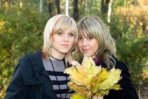 ritratto di il Due giovane donne con autunno le foglie foto