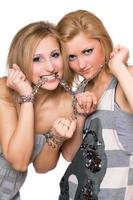 Due giocoso giovane donne limite un' catena foto
