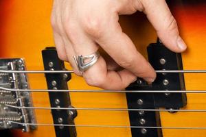 mano di il chitarrista su chitarra stringhe foto