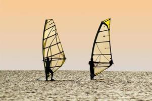 sagome di Due windsurfisti su onde di un' golfo foto