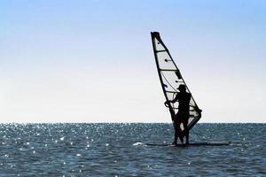 silhouette di un' windsurfista foto