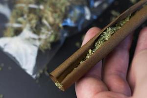 uomo detiene smussato carta con cannabis, marijuana su sfondo nel pacchetto, copia spazio foto