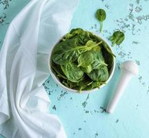 crudo verde spinaci le foglie nel un' bianca ceramica ciotola foto