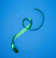 verde seta magro nastro contorto su un' blu sfondo foto