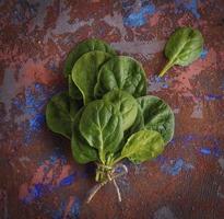 un' mazzo di verde spinaci le foglie su un' Marrone sfondo foto