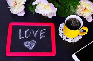 tazza di caffè e un' nero gesso placca con amore foto