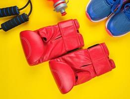 paio di rosso boxe guanti e blu scarpe da ginnastica foto