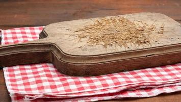 vuoto vecchio di legno taglio tavola e piegato rosso e bianca cotone cucina tovagliolo su un' di legno Marrone sfondo, superiore Visualizza, copia spazio foto