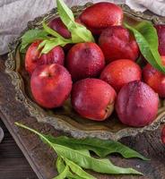 rosso maturo Pesche Nettarina nel un ferro piatto foto