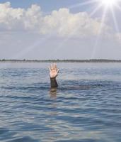 dell'uomo mano bastoni su a partire dal il acqua nel il mezzo di il oceano foto