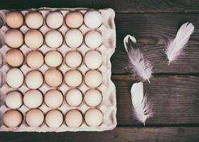 crudo pollo uova nel un' carta contenitore foto