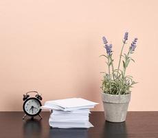 pila di bianca piazza Nota documenti, un' ceramica pentola di lavanda e un allarme orologio foto