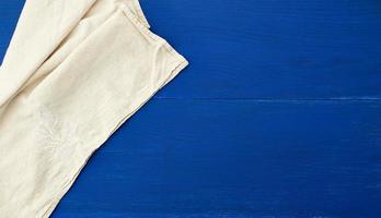 bianca cucina tessile asciugamano piegato su un' blu di legno tavolo a partire dal vecchio tavole foto