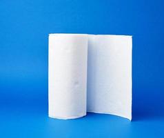 contorto rotolo di bianca carta asciugamano su un' blu sfondo foto
